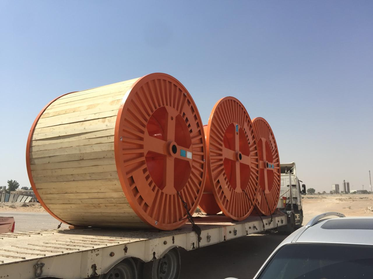 Orange cable drums loaded on a flatbed trailer for dispatch