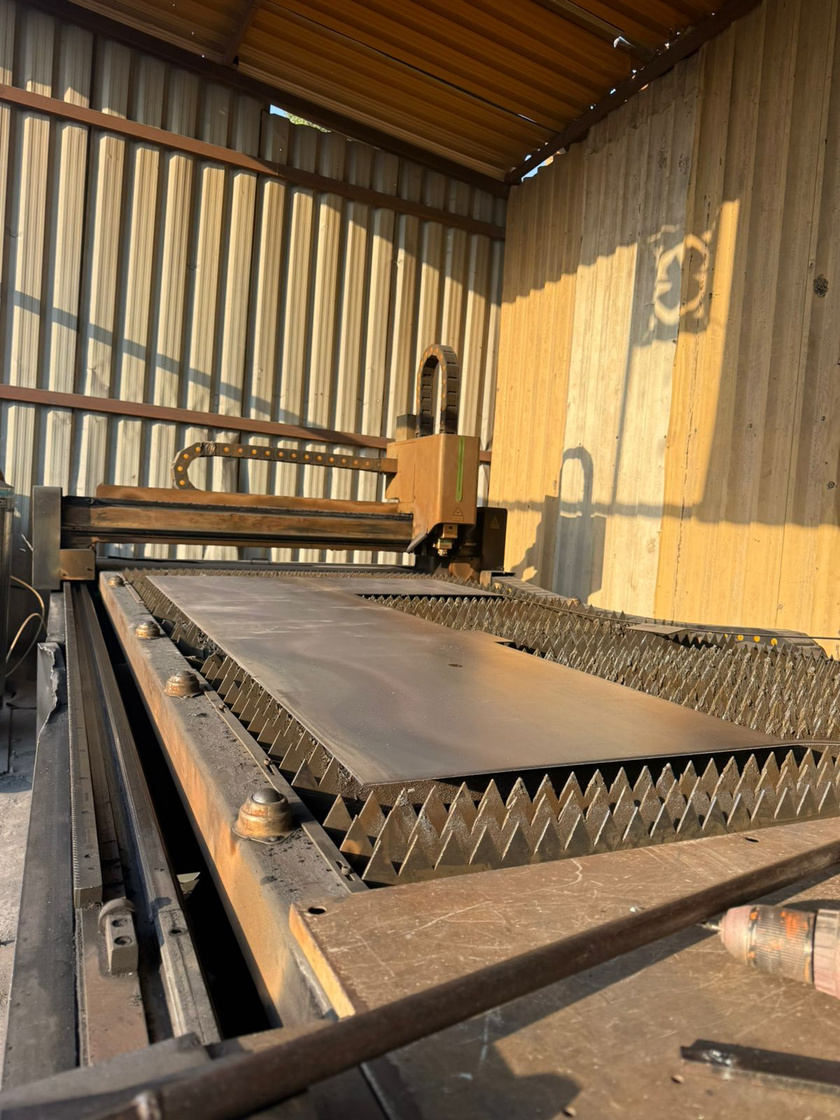 CNC laser cutting machine with a steel sheet on the bed
